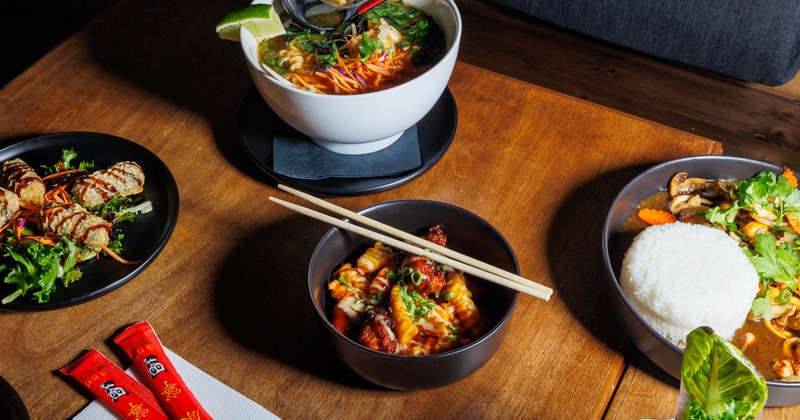Assorted dishes including soup and rice on wooden table