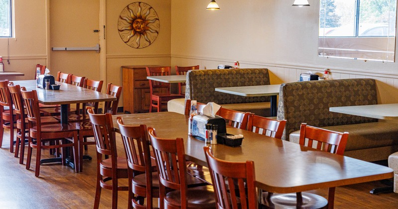 Interior, long wooden dining tables and chairs, booth area on the right