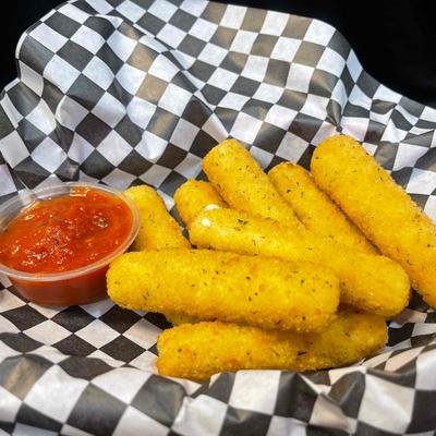 Mozzarella sticks and a cup of marinara sit on black and white checkered paper.