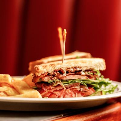 Hearty club sandwich served with french fries.