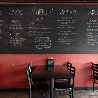 Interior with a dining table and a wall-mounted chalkboard menu.
