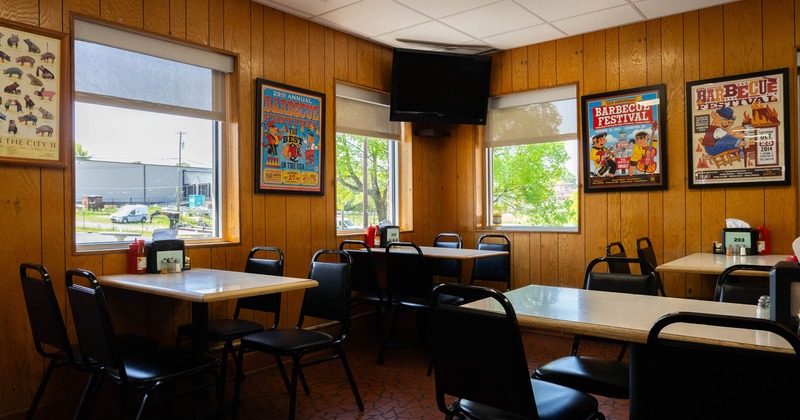 Interior seating area with chairs and tables, vintage barbecue posters decor