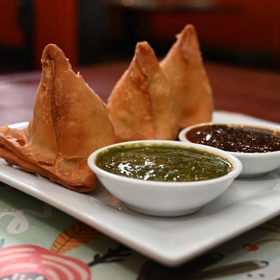 Three Samosas served with dips.