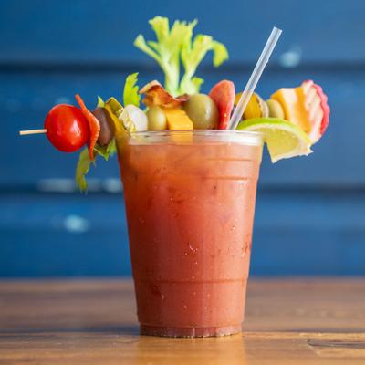 Bloody Geisha cocktail garnished with a cheese, olives, pickle and vegetables on a skewer.