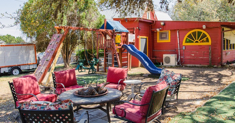 Exterior, daylight,  seating around a fire pit, playground area for kids