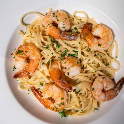 Shrimp Scampi with spaghetti, topped with fresh herbs.
