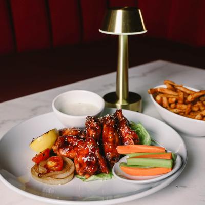 Barbecue wings served with vegetable sticks, dipping sauce and side of fries.