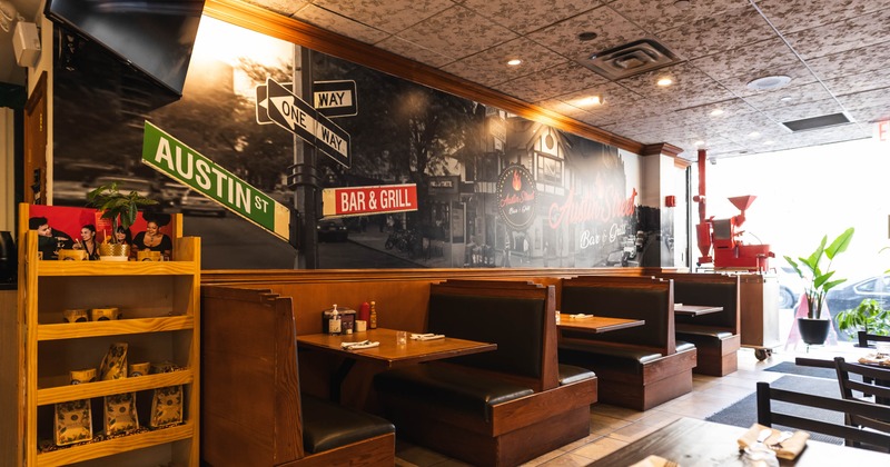 Interior with mural of street signs and a row of wooden booths.