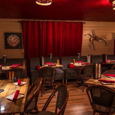 Wooden interior design, dining area, tables and seating with tableware.