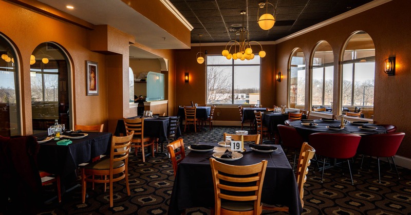 Interior, dining area, tables for three, four and six, kitchen in the back, chandeliers