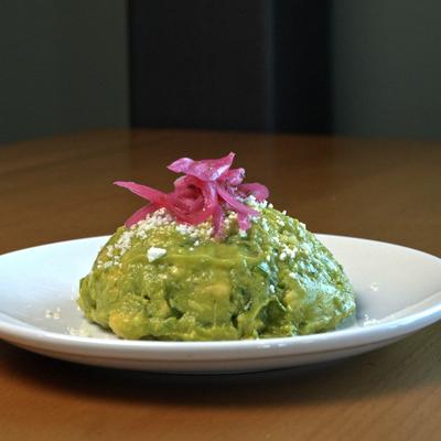 Fresh guacamole topped with pickled red onions.