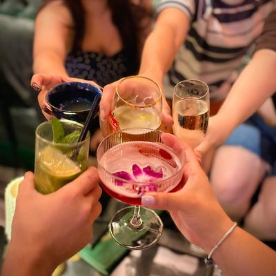 People toasting with cocktails in hand.