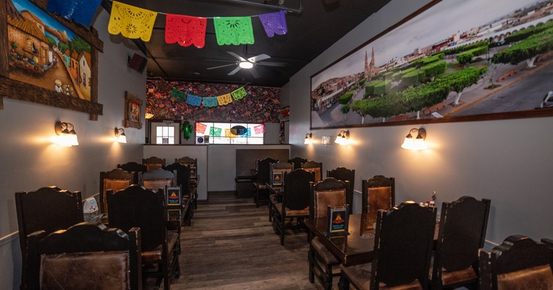 Interior with wooden tables and chairs and large panoramic photo on the wall.