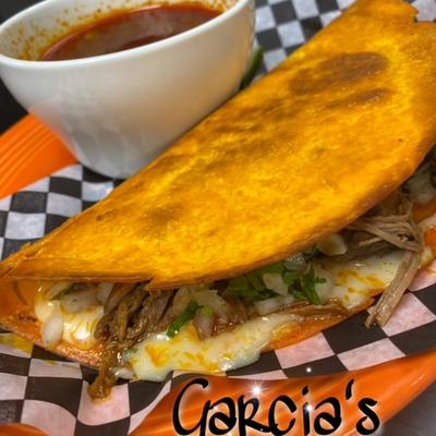 Quesabirria taco with cheese and birria meat, served with consomme.