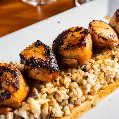 Blackened Scallops, served over a creamy medley mushroom risotto.