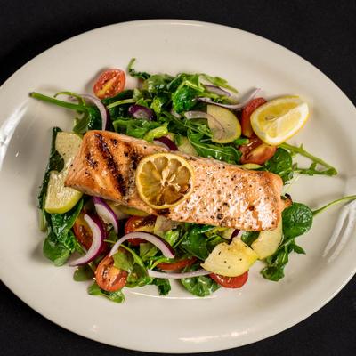 Grilled salmon on a bed of fresh salad.