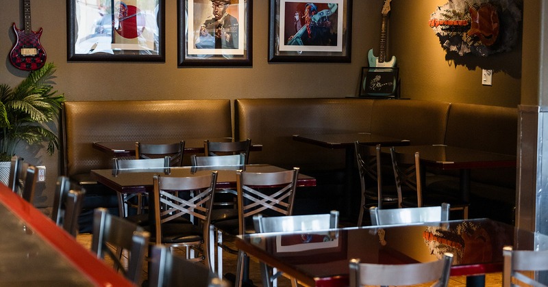 Cozy and modern interior seating area with upholstered seats in the corner and lined-up tables