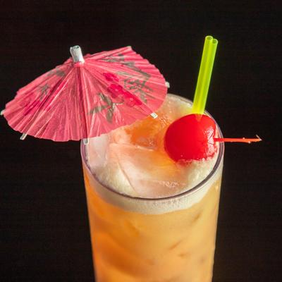Tropical cocktail with cherry and paper umbrella garnish.
