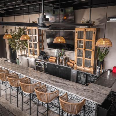 Spacious bar with wicker stools and wooden cabinets.