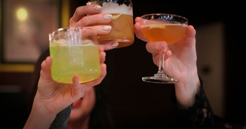 Three  people toasting with cocktails