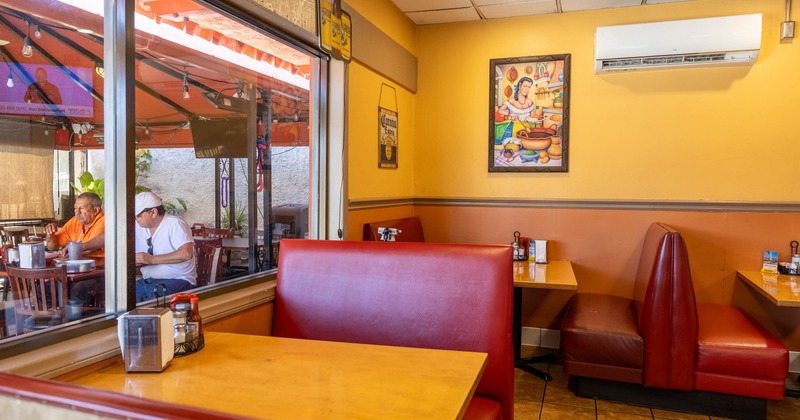 Cozy restaurant interior with red booths and warm yellow walls