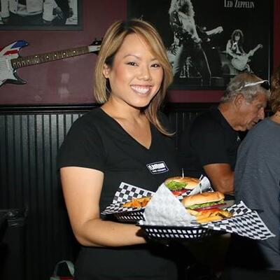 Staff member serving food, posing for a photo