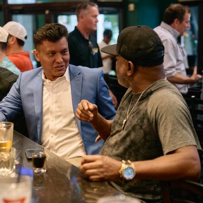 Two patrons chatting at a bar counter.