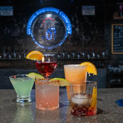 Assorted cocktail drinks set on a bar counter.