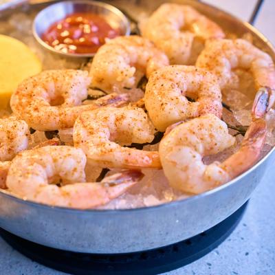 Seasoned fresh shrimp with cocktail sauce.