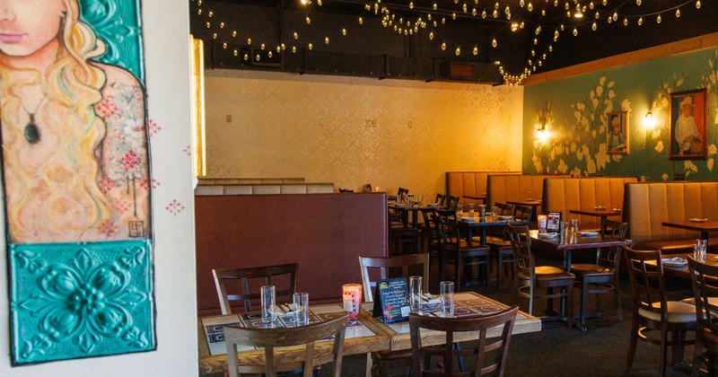 Warmly lit interior with leather booths, wooden chairs and tables.