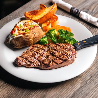Grilled ribeye steak, stuffed baked potato, broccoli, carrots, and toast.