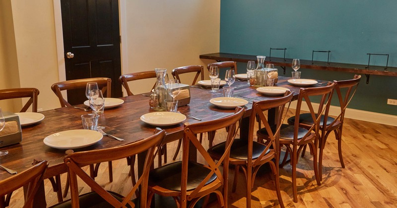 Interior, long wooden table setup with wooden chairs, ready for guests