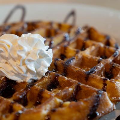 Waffle, with chocolate drizzle, and whipped cream.