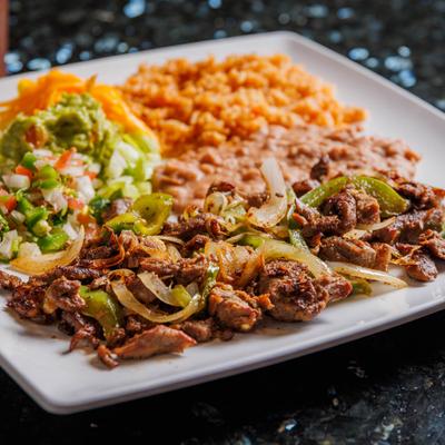 Beef fajitas served with rice, refried beans, lettuce, pico de gallo, guacamole