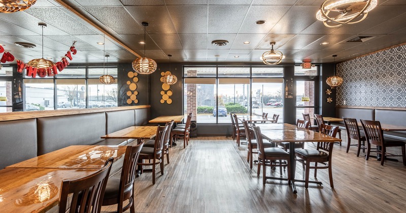 Banquette seating by the walls with dining tables in the middle of the room