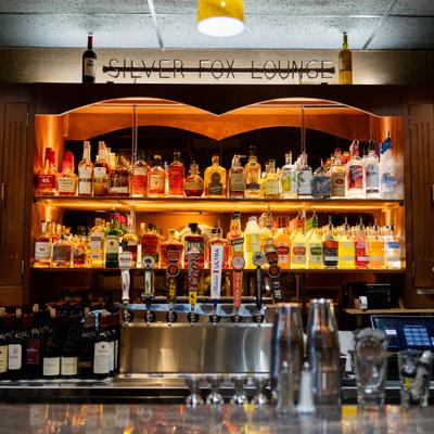 Bar area with backlit liquor shelves and beer taps.