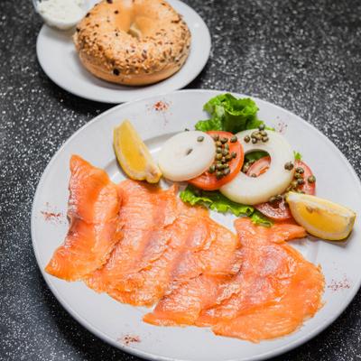 Smoked salmon served with a seeded bagel and garnishes.