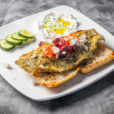 Mediterranean Omlette erved on toasted bread with sides.