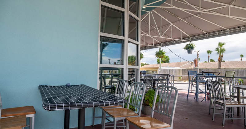 Outdoor dining area featuring a round black grid patterned table and metal chairs