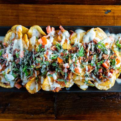 Chips topped with warm blue cheese sauce, bacon, tomatoes and green onions.