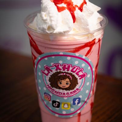 Strawberry milkshake with whipped cream and syrup.
