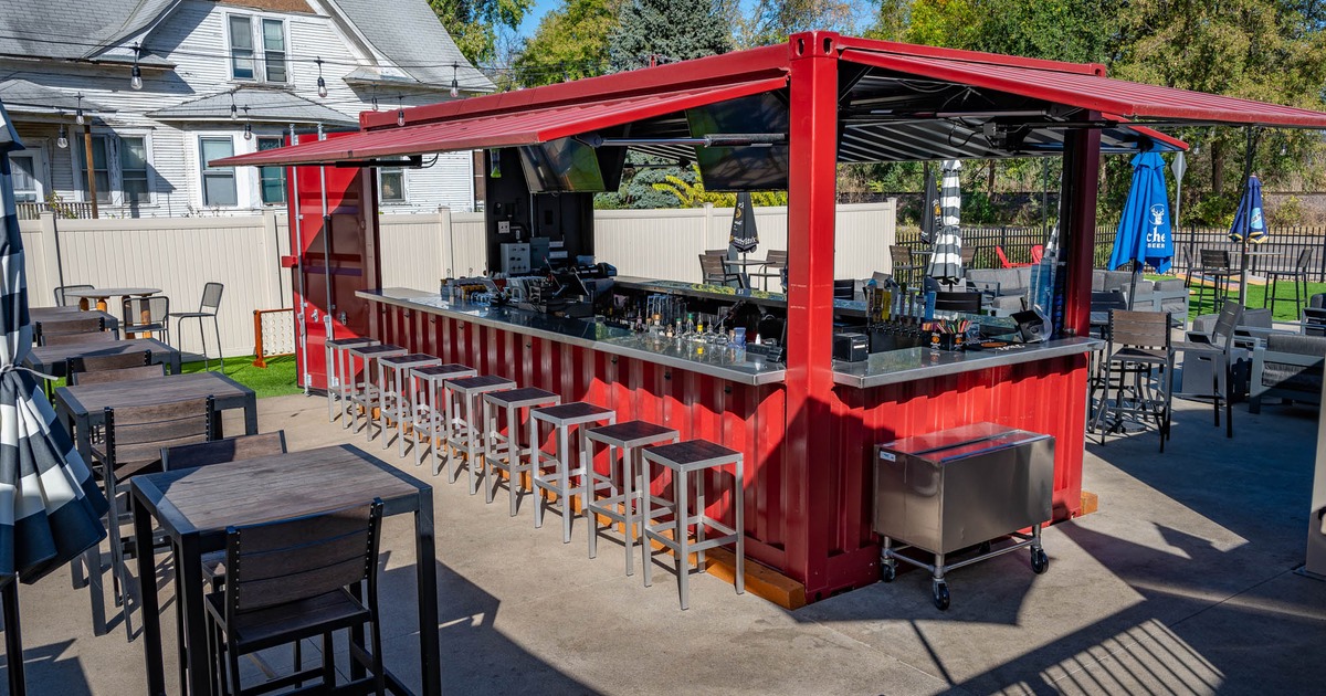 Exterior, outdoor bar made out of shipping container, high tables with stools