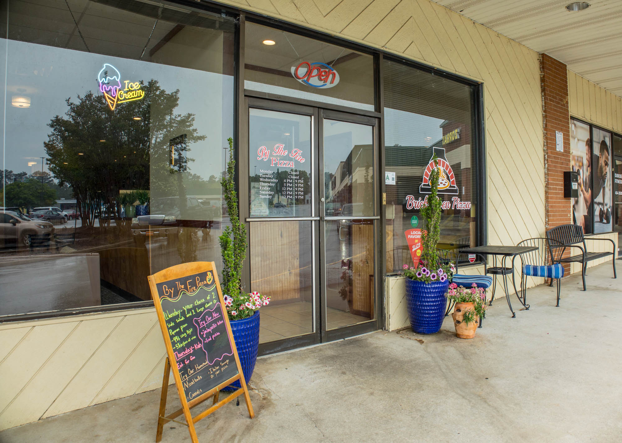 Storefront with signage, outdoor seating, and a menu board