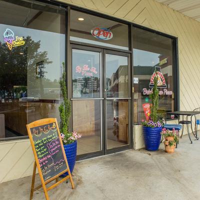 Storefront with signage, outdoor seating, and a menu board.