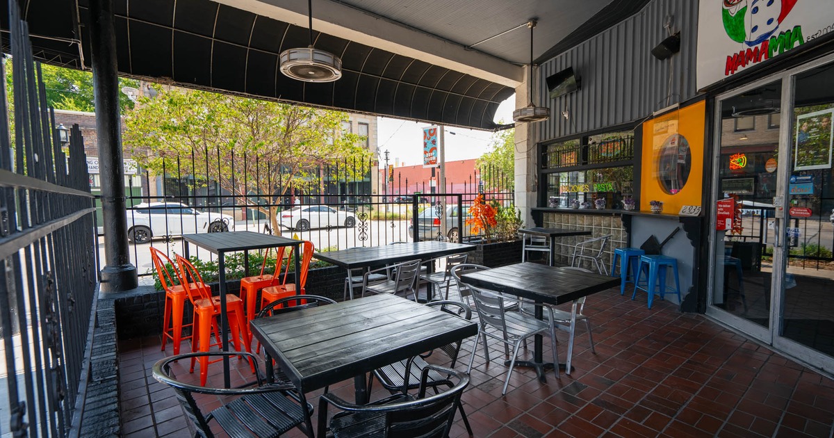 Outdoor restaurant patio with tables, chairs, and vibrant decor
