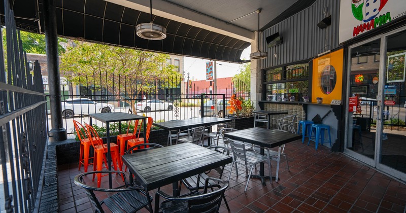 Outdoor restaurant patio with tables, chairs, and vibrant decor