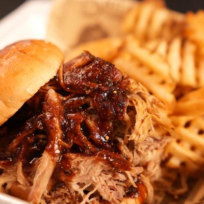 BBQ pulled pork sandwich served with waffle fries.
