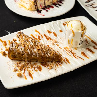 Apple crumb cake served alongside a scoop of vanilla ice cream.