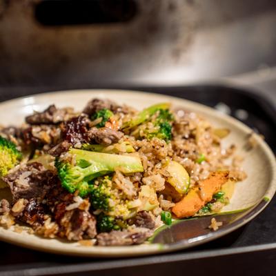 A plate of beef and broccoli fried rice sits on a tray.