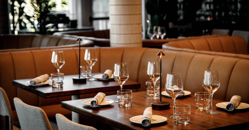 A beautifully set restaurant table with wine glasses and modern table lamps